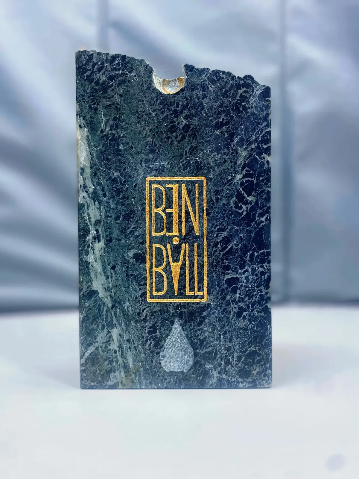 Dark marble block with gold BEN BALL lettering